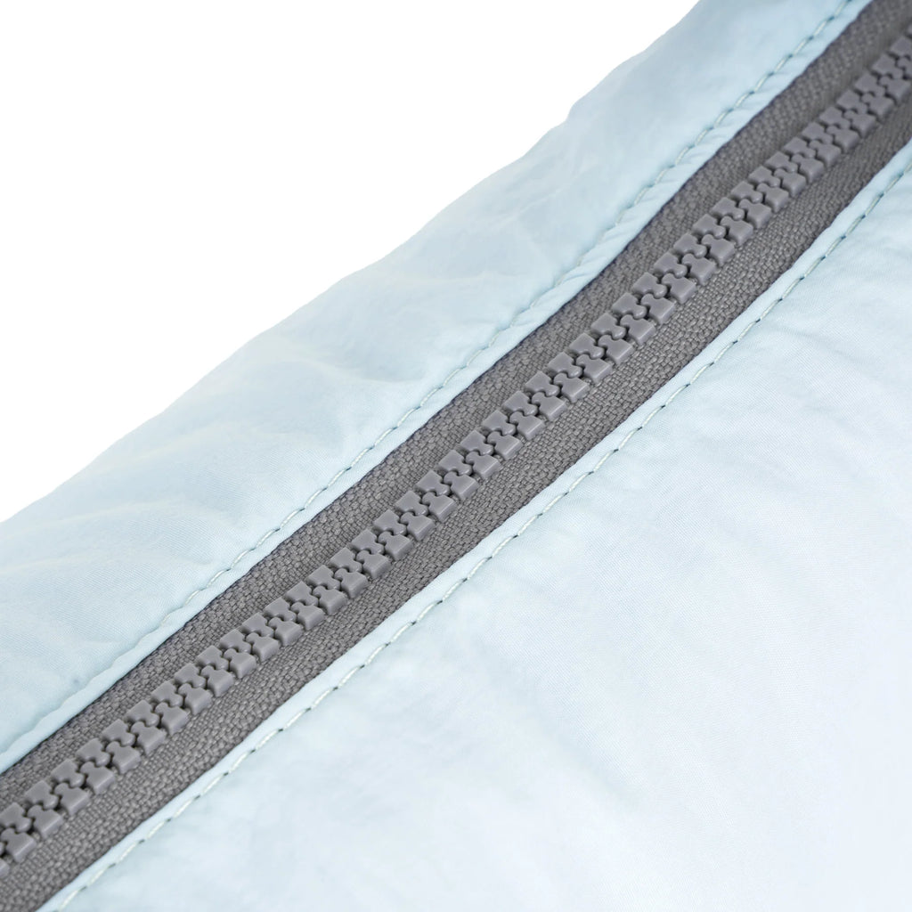 Close-up of a light blue ROKA product featuring a gray zipper.