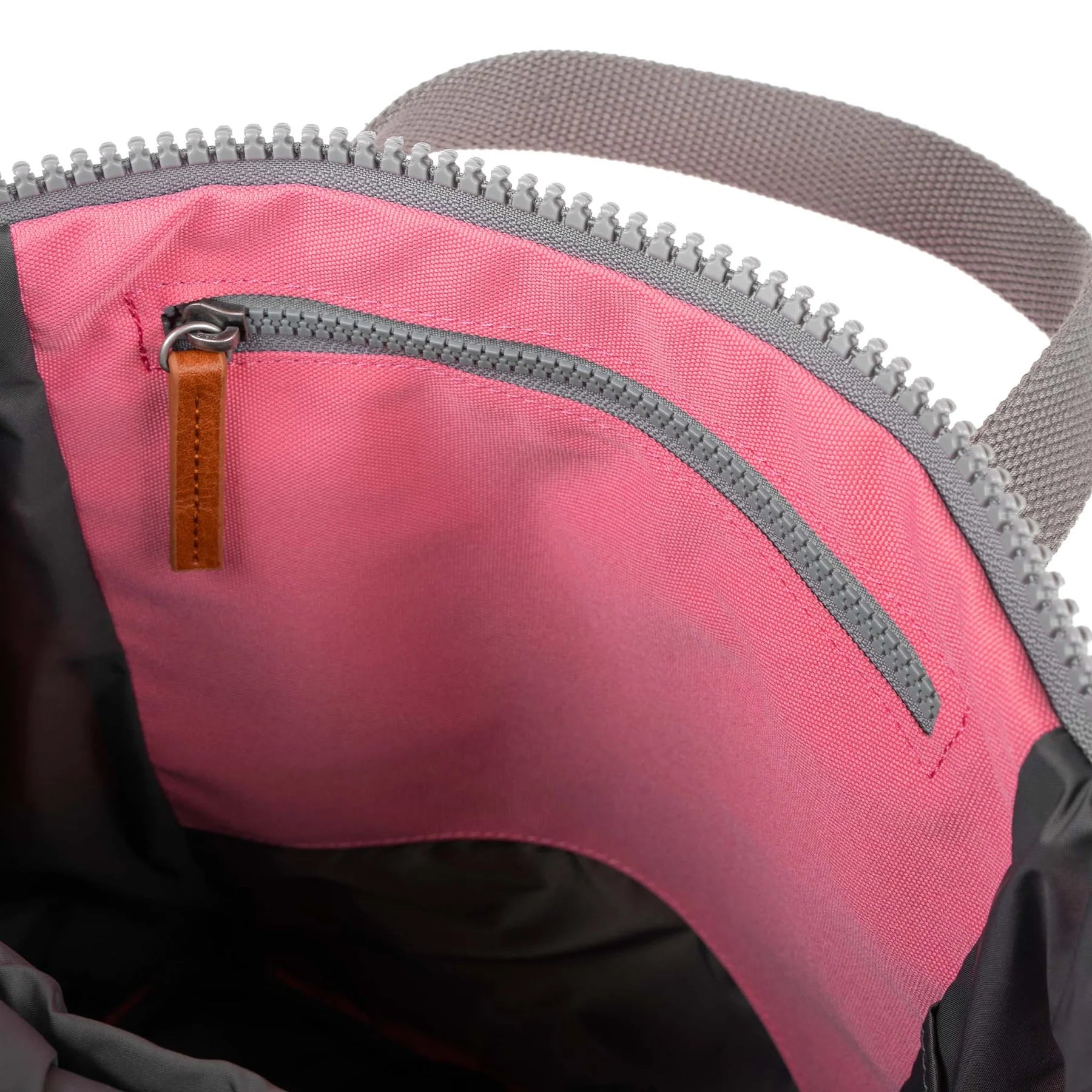 Inside view of a ROKA bag, featuring a pink lining and a zipper pocket with a leather pull.