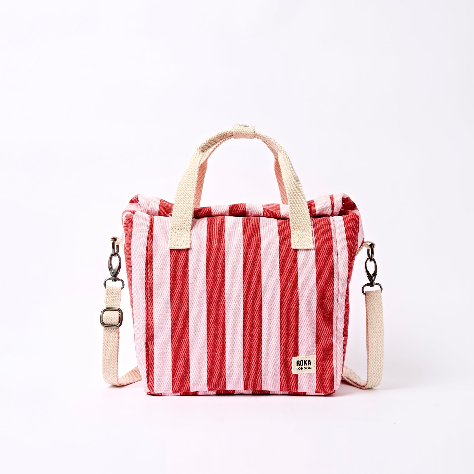 Red and white striped bag with beige handles and strap on a white background