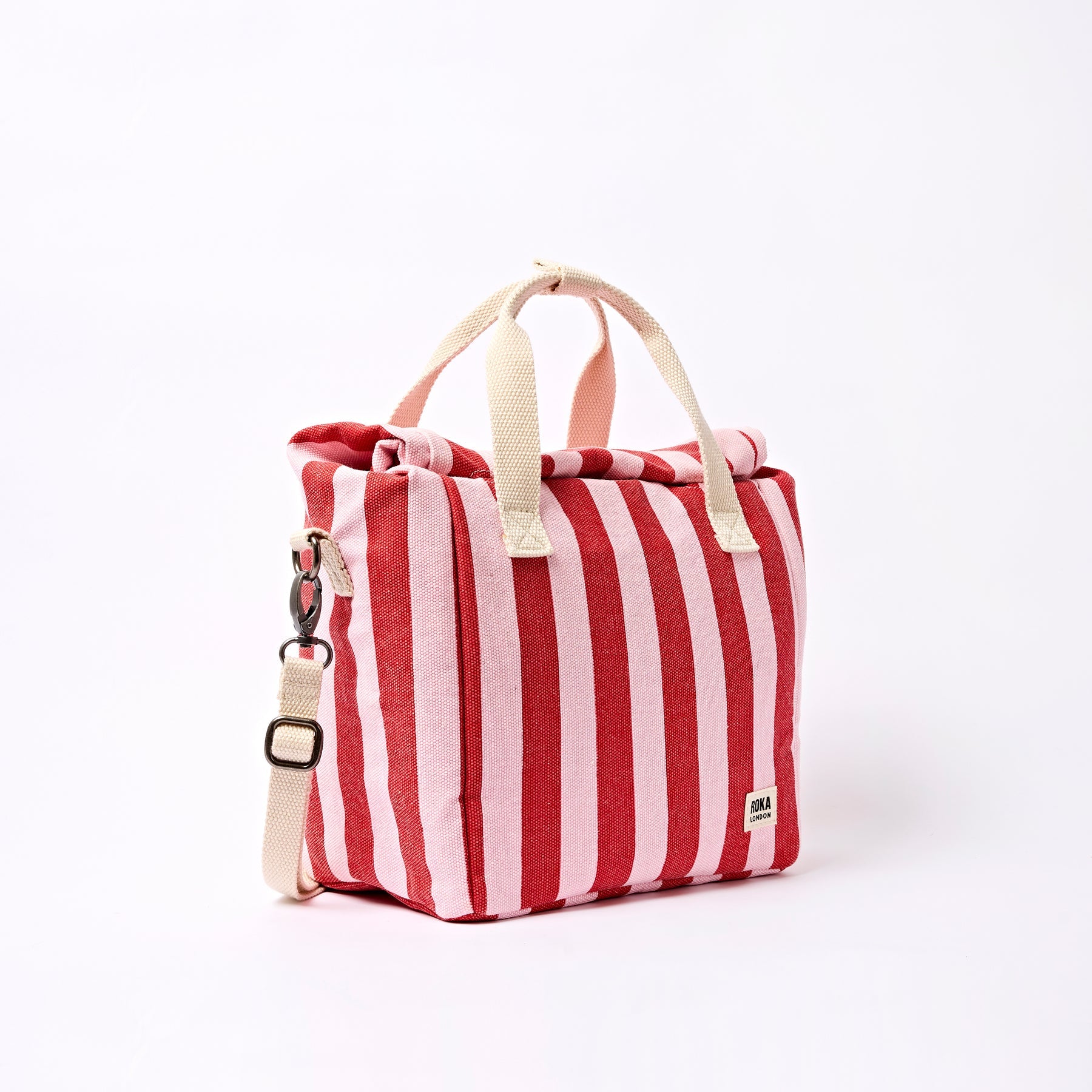 Red and white striped bag with beige handles and strap on a white background