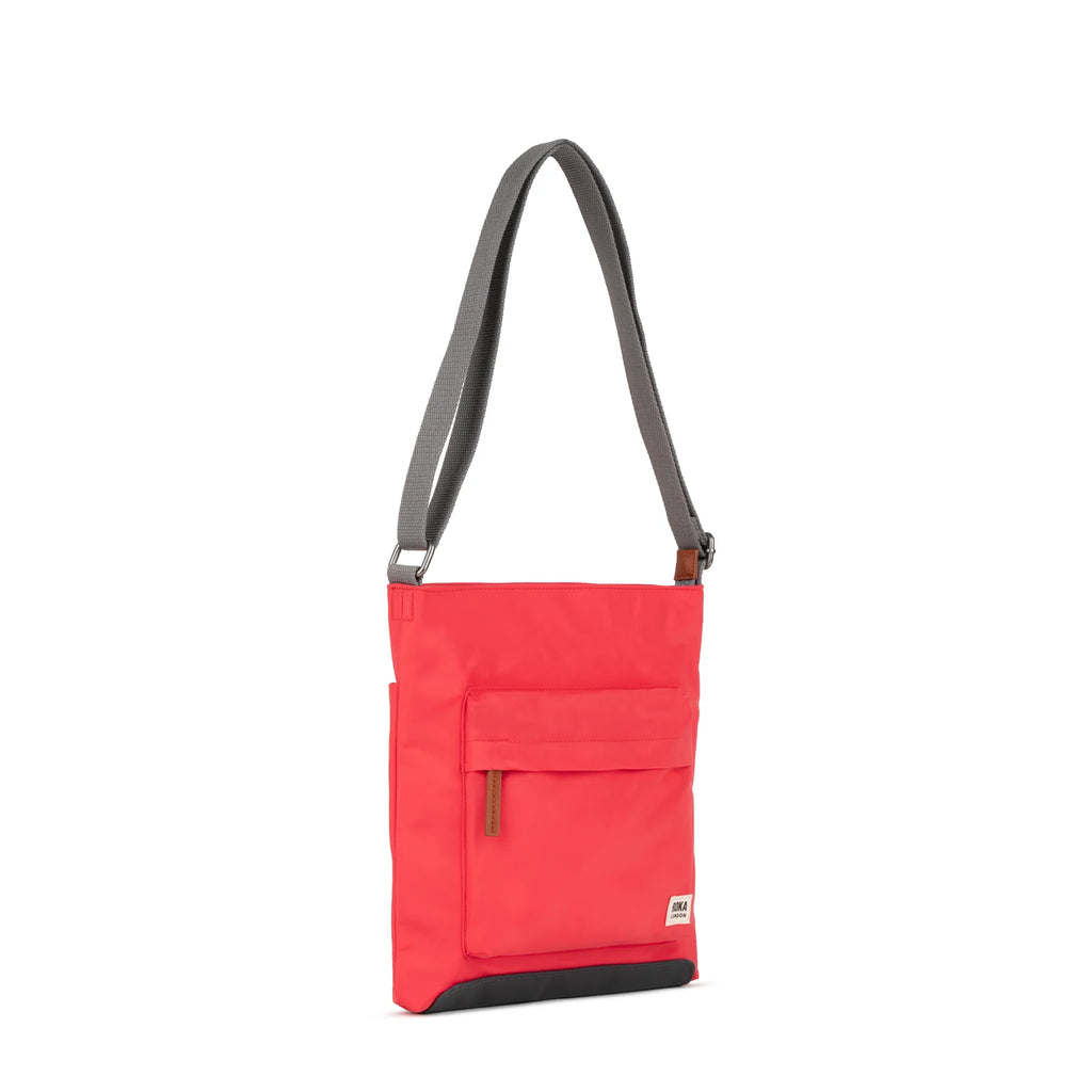 ROKA tote bag in vibrant red with a gray strap and front pocket, stylish and functional for everyday use.