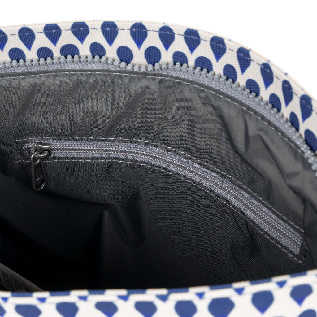 Close-up of a ROKA bag's interior, featuring a zippered pocket against a patterned lining.