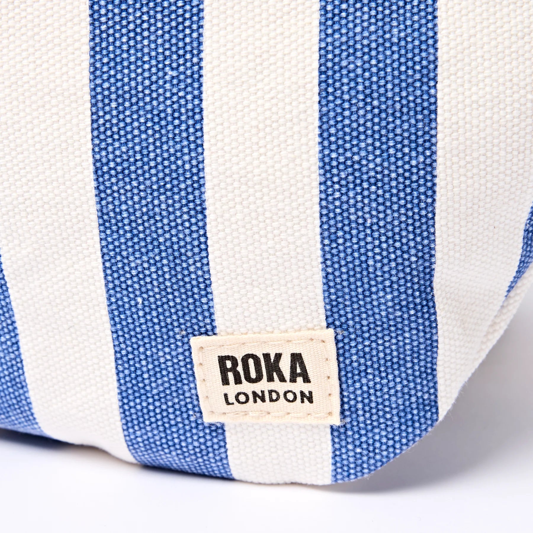 Blue and white striped bag with Roka London label on a white background