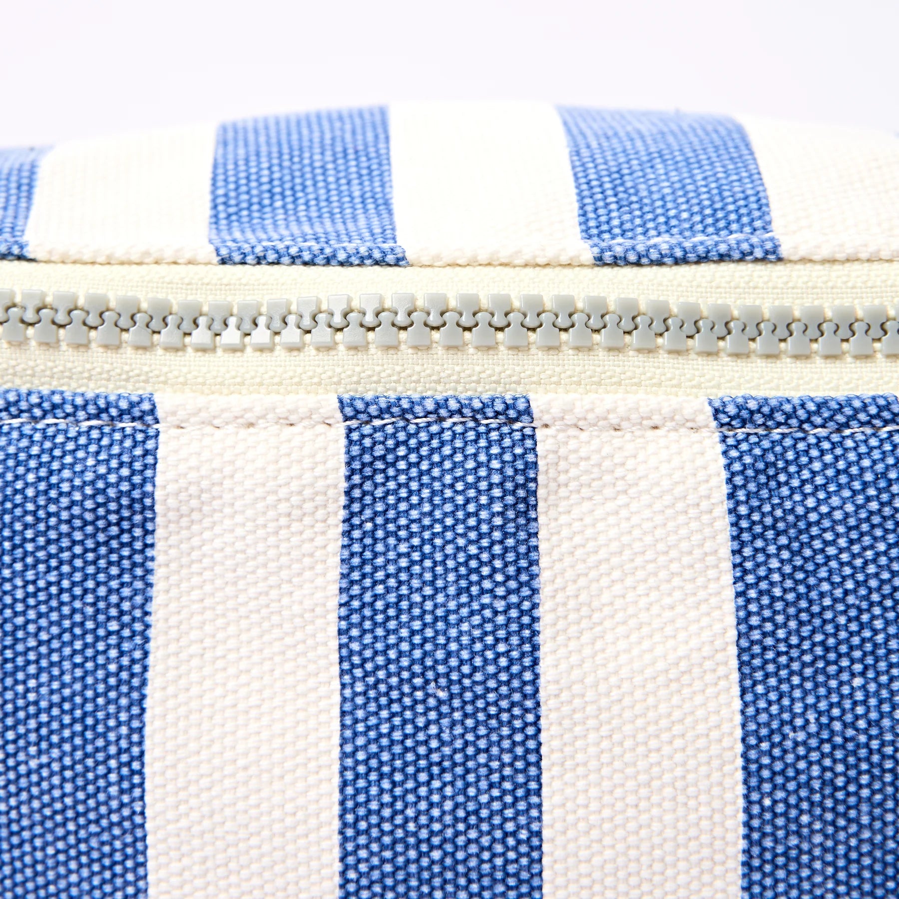 Close-up of a bag with blue and white striped pattern and zipper.