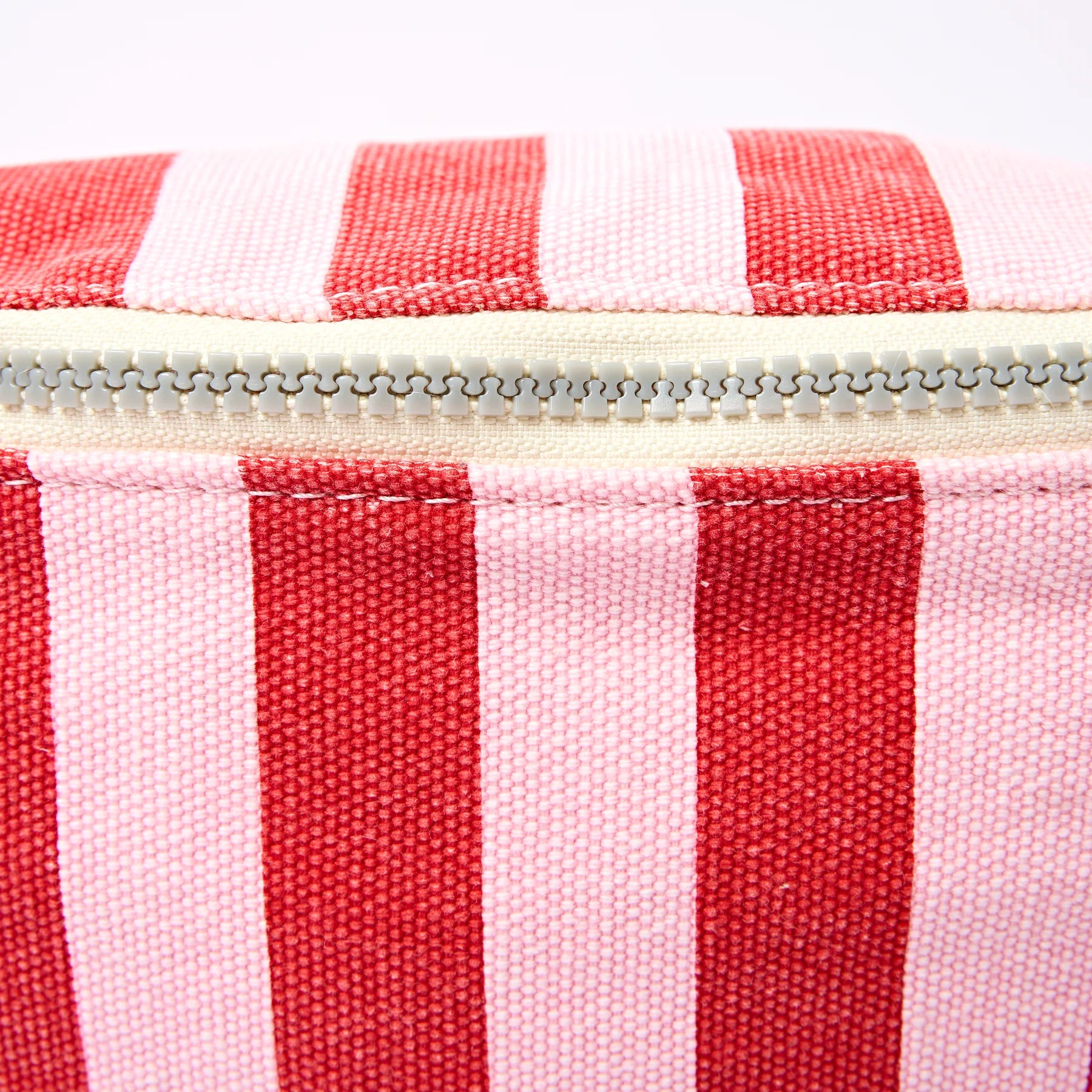 Close-up of a red and white striped fabric with a zipper.