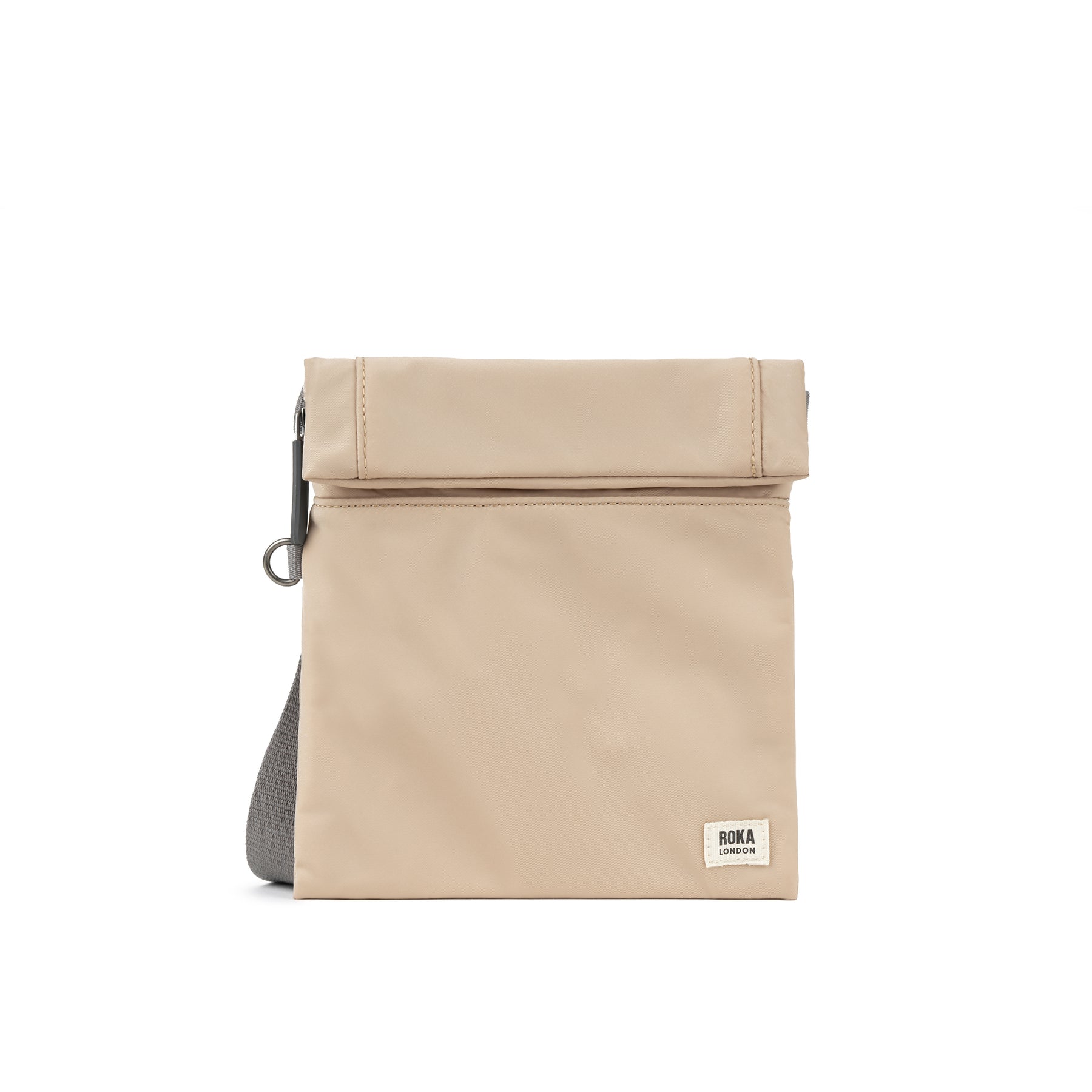 Beige foldover bag with a gray strap and ROKA London branding on the front. Simple and stylish design.