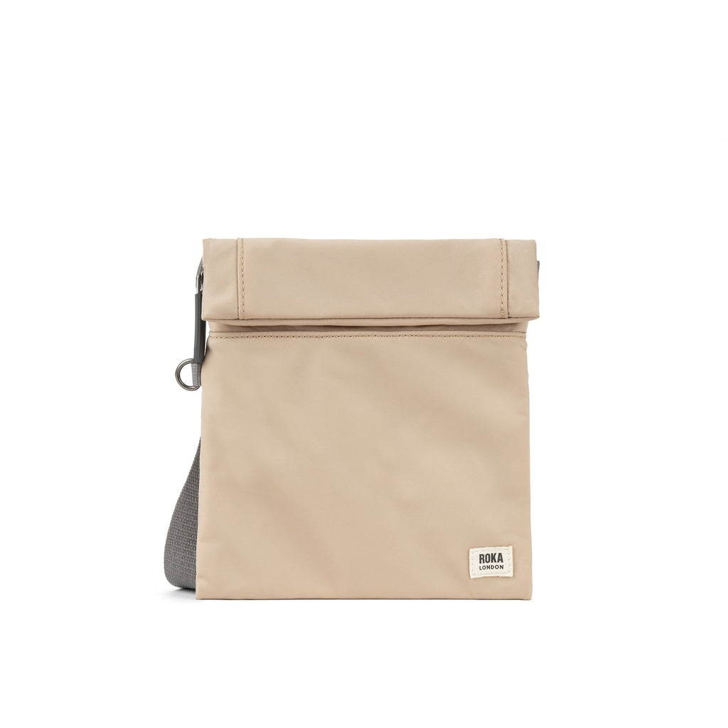 Beige foldover bag with a gray strap and ROKA London branding on the front. Simple and stylish design.