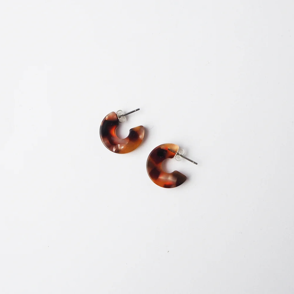 Pair of tortoiseshell-patterned resin hoop earrings with silver posts.