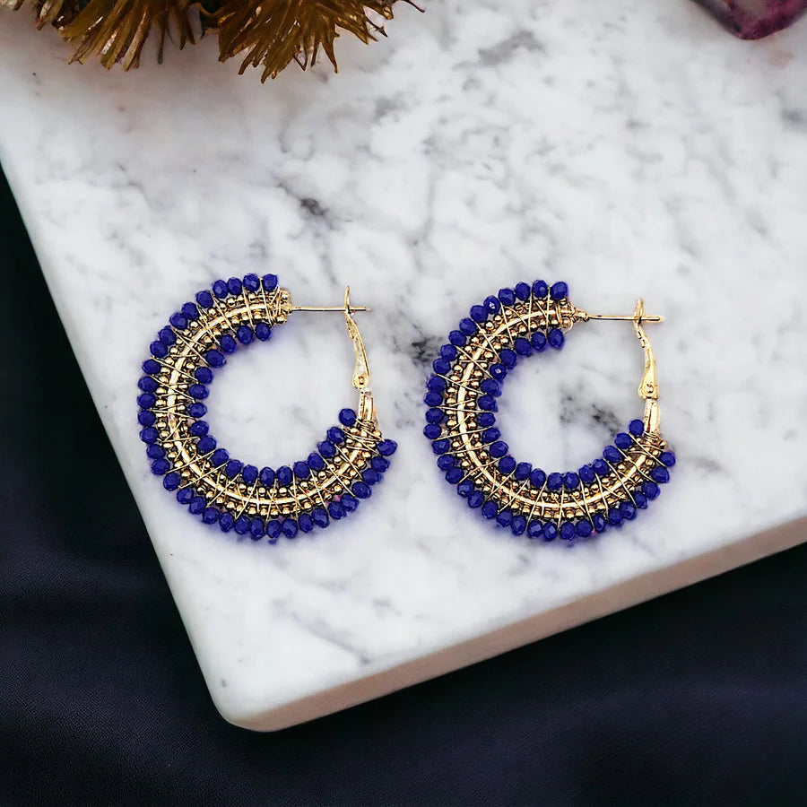 Pair of gold and dark blue beaded hoop earrings.