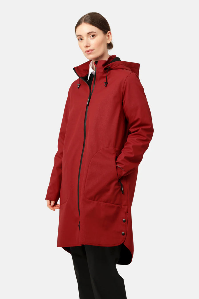 Woman in a burgundy, long-sleeved, hooded raincoat with black zipper and accents. The coat has a curved hem and side pockets.