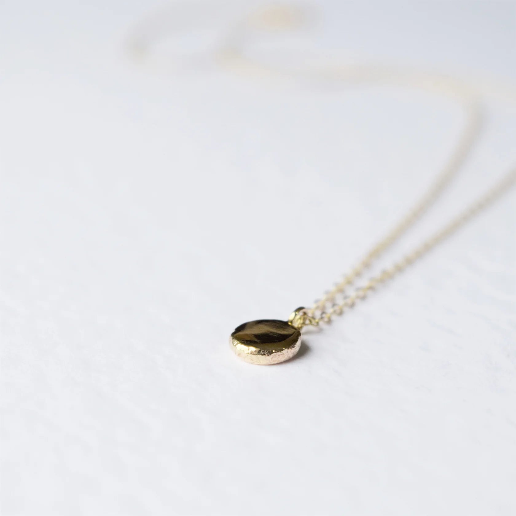Gold necklace with a pendant on a white background