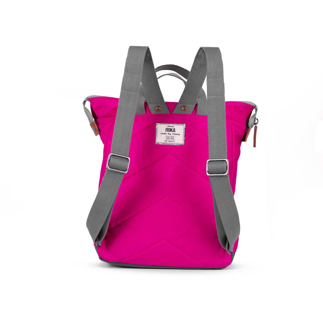 Hot pink backpack with gray straps and chevron quilting. Features a small top handle and a brand label.