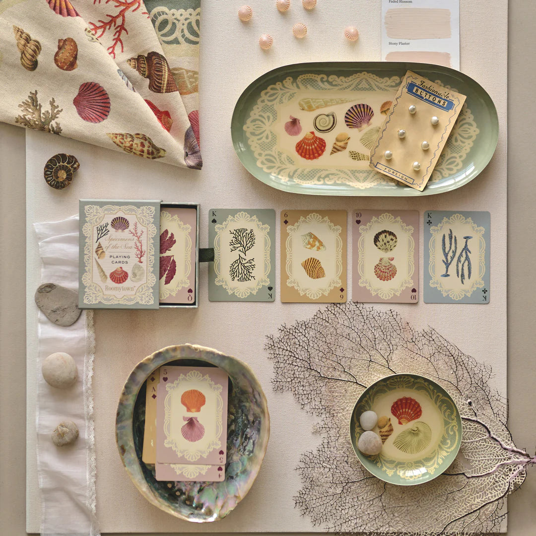 Collection of decorative items including cards, trays, and stationery on a neutral background.
