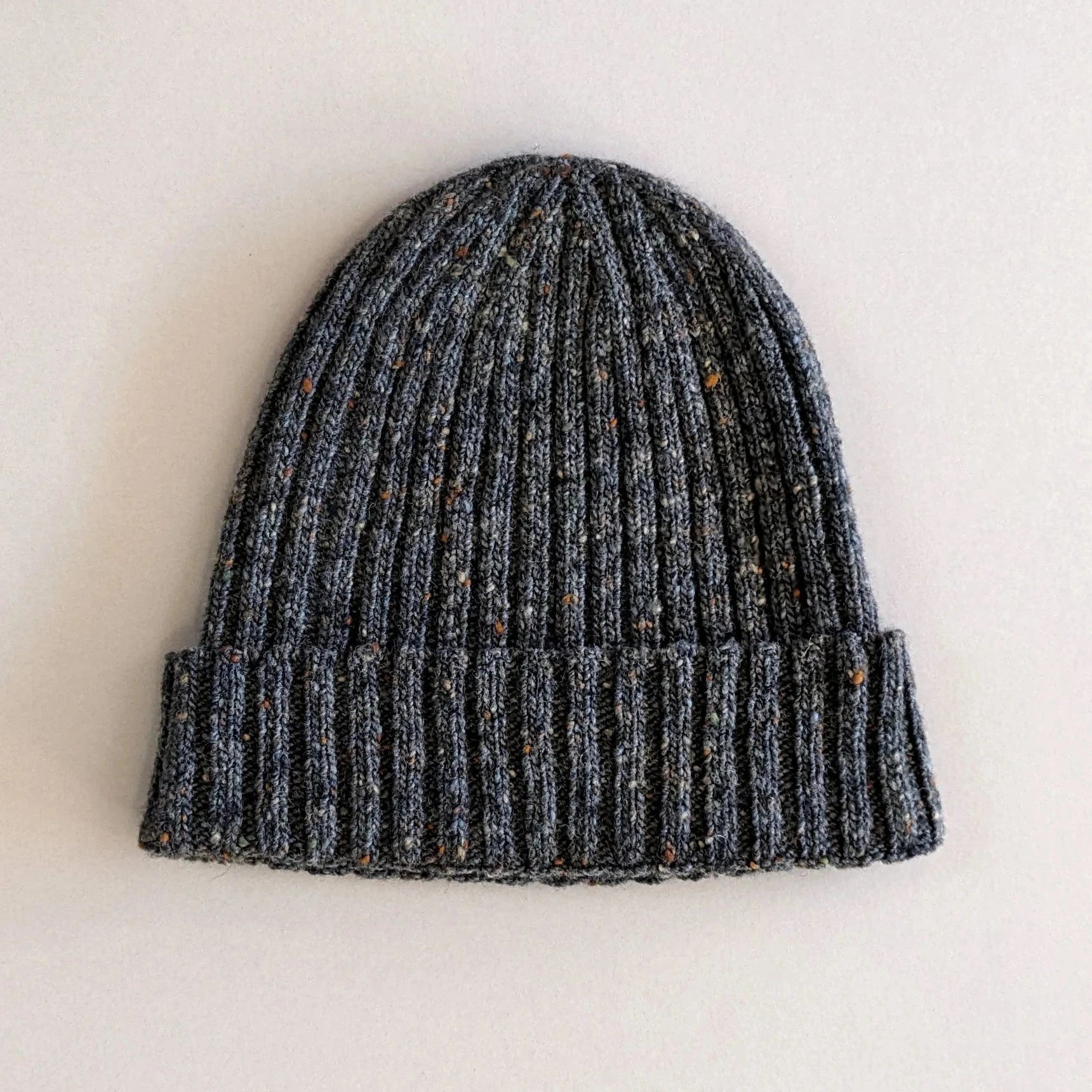 Dark gray ribbed knit beanie with flecks of lighter gray and brown throughout.
