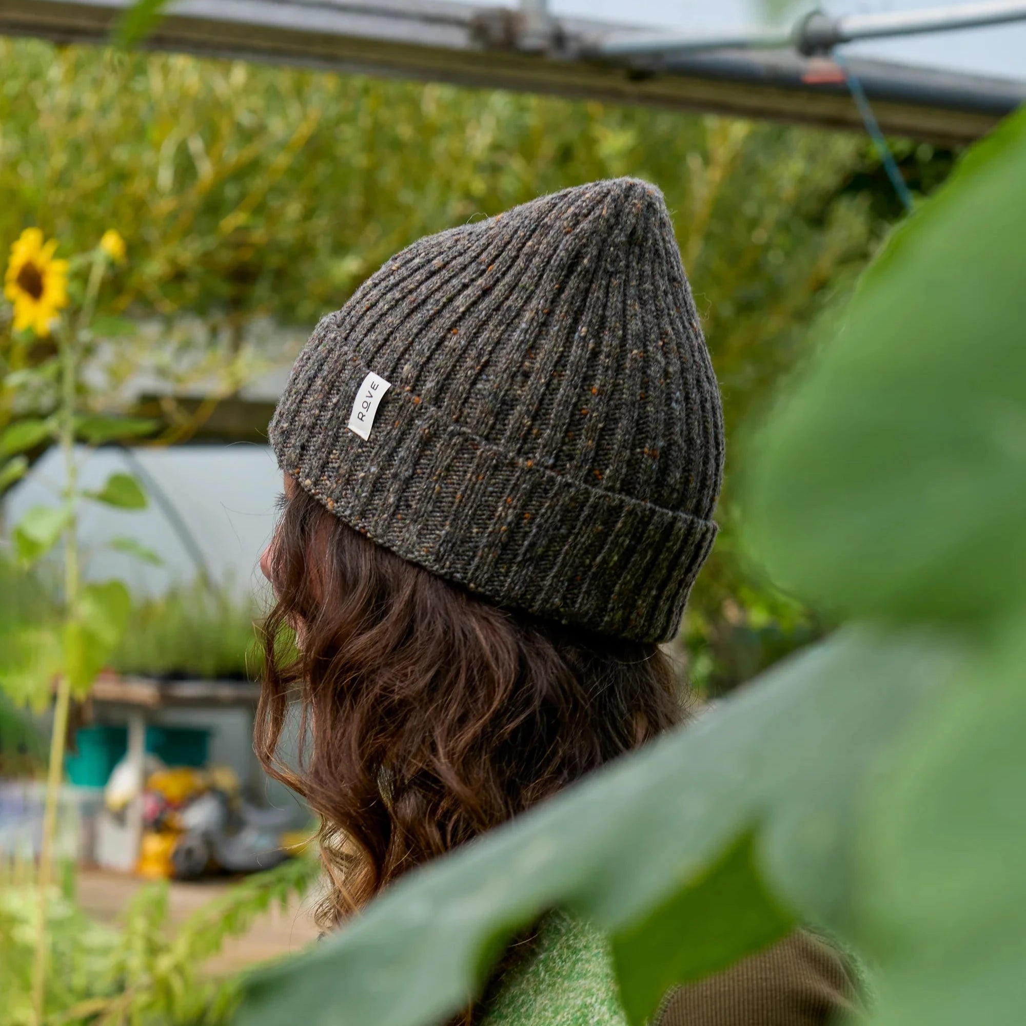 Dark gray ribbed knit beanie with small multicolored flecks and a small white label.