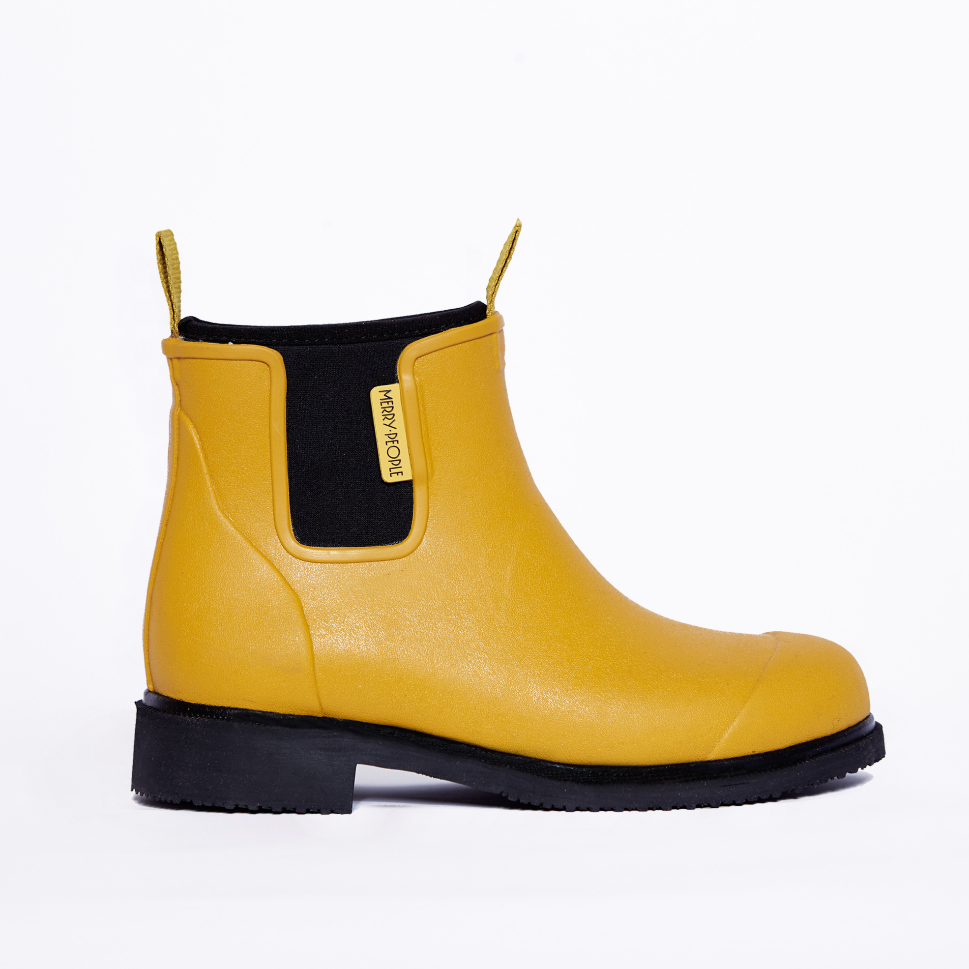 Mustard yellow rubber ankle boot with black sole and back panel.  Features a small yellow pull tab.