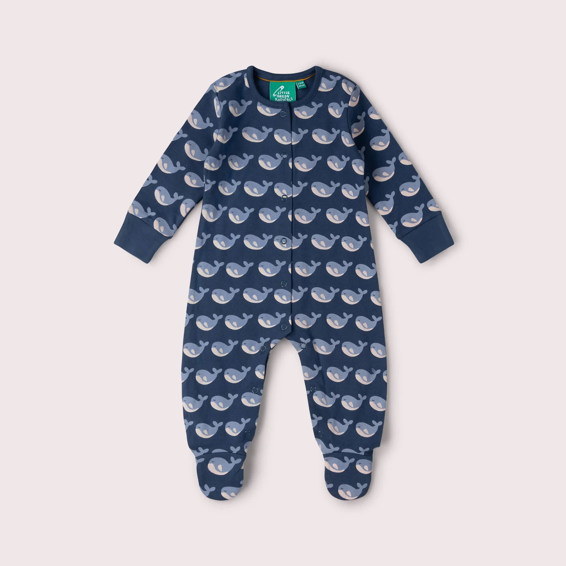 Navy blue baby onesie with whale pattern on a light gray background