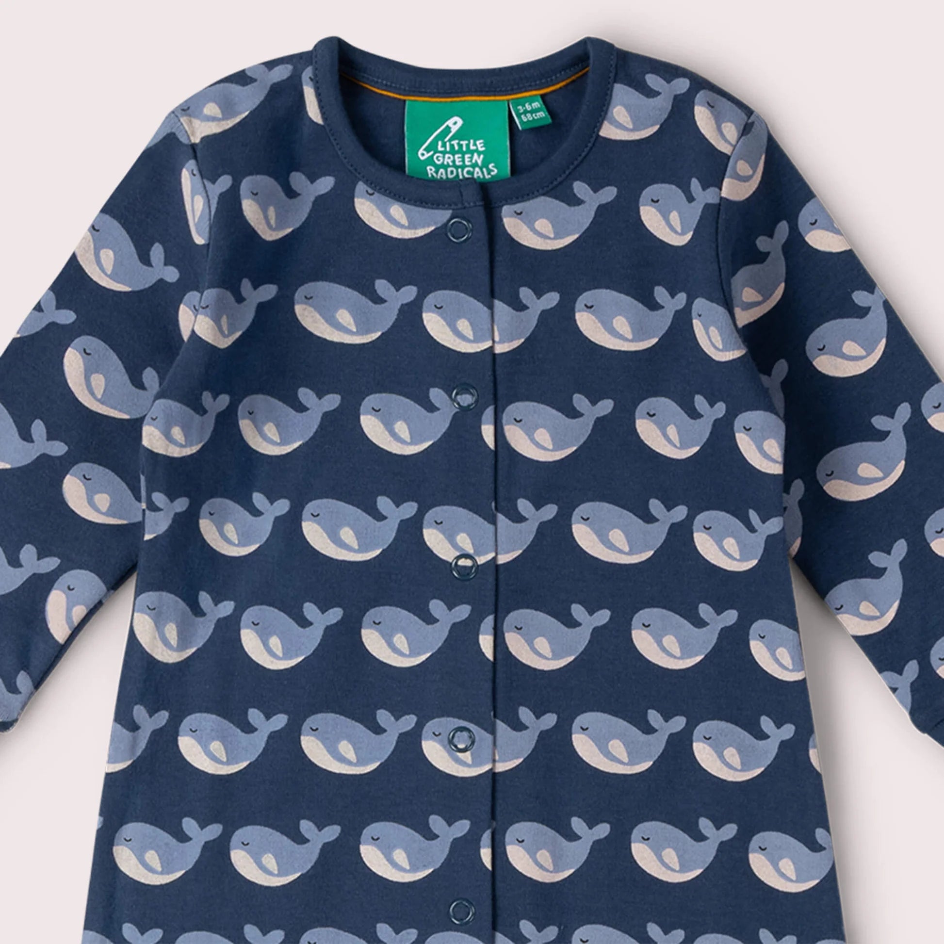Navy blue children's onesie with whale pattern on a white background