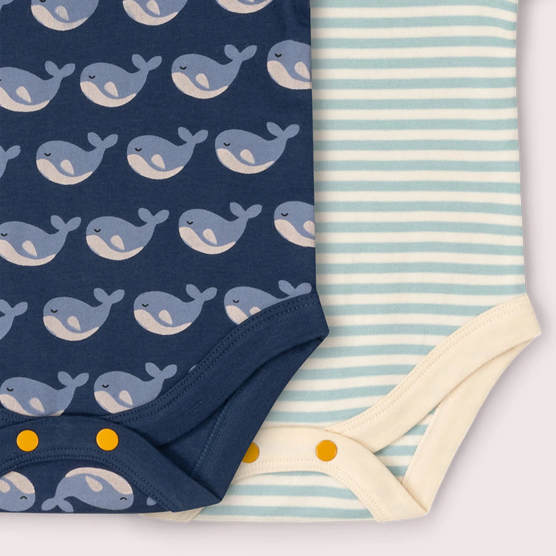 Navy fabric with whale pattern and light blue and white striped fabric with yellow dots on a white background