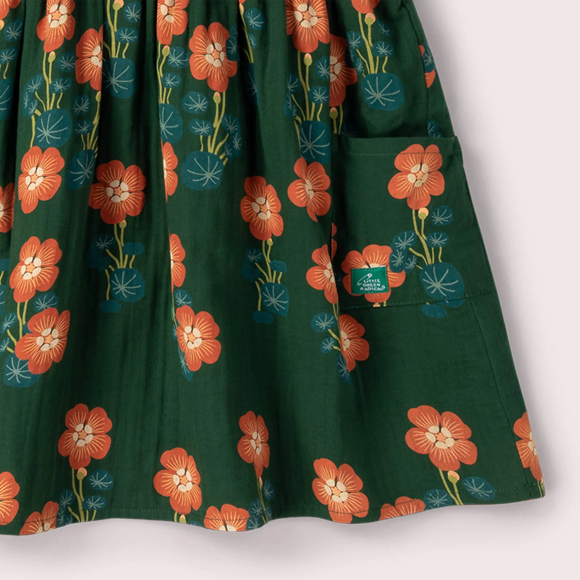 Green fabric with orange floral pattern on a white background