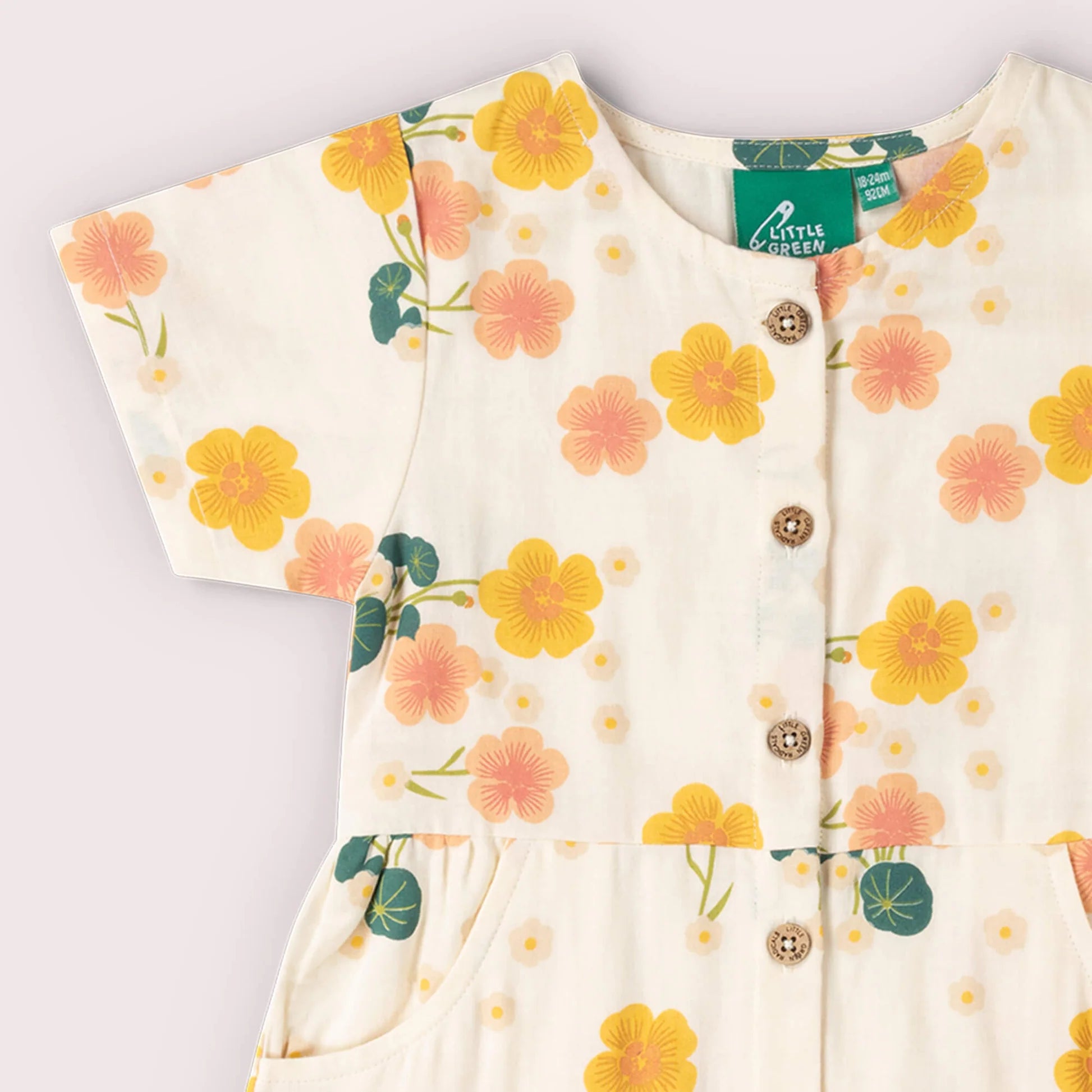 Floral-patterned baby outfit with buttons on a light background