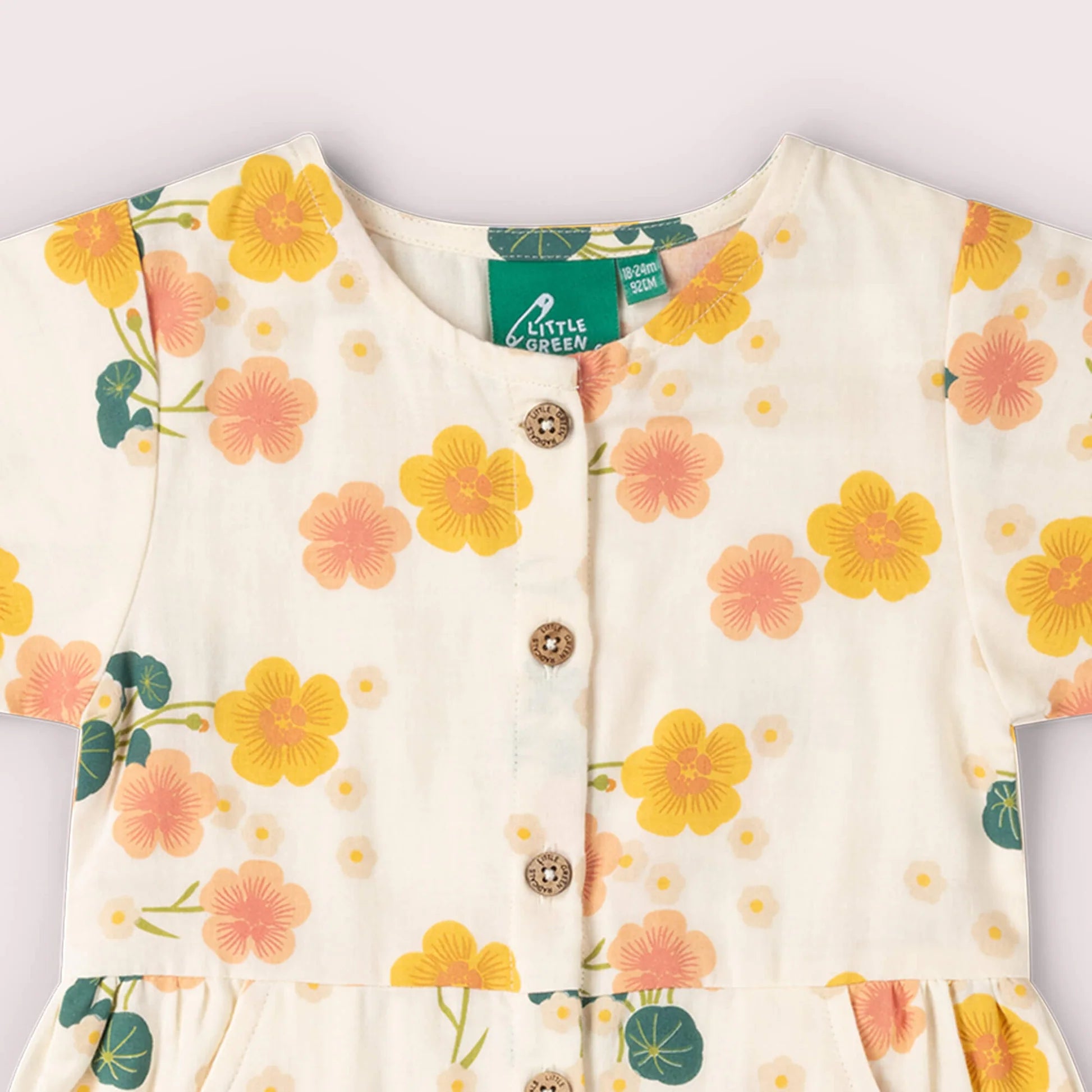 Floral-patterned baby outfit with buttons on a white background, featuring the brand 'Little Green Radicals'.