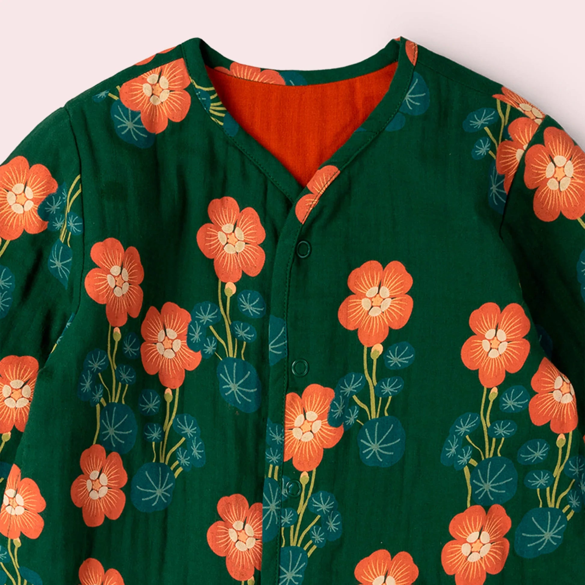 Green shirt with orange floral pattern on a white background