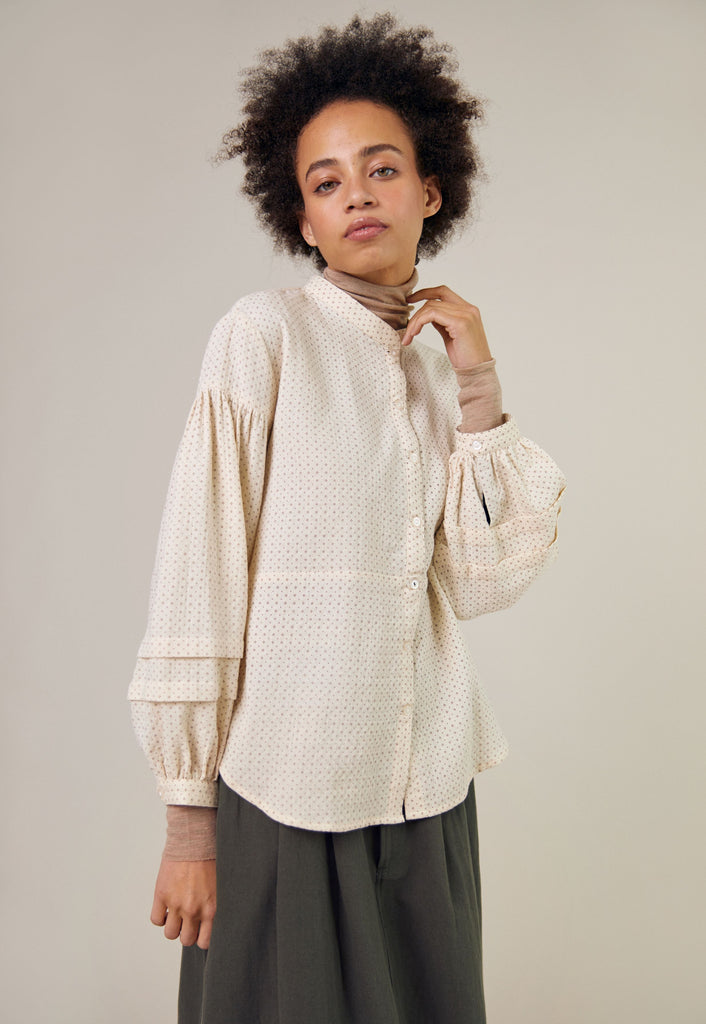 Off-white collared shirt with a subtle repeating pattern, featuring long balloon sleeves and a relaxed fit.