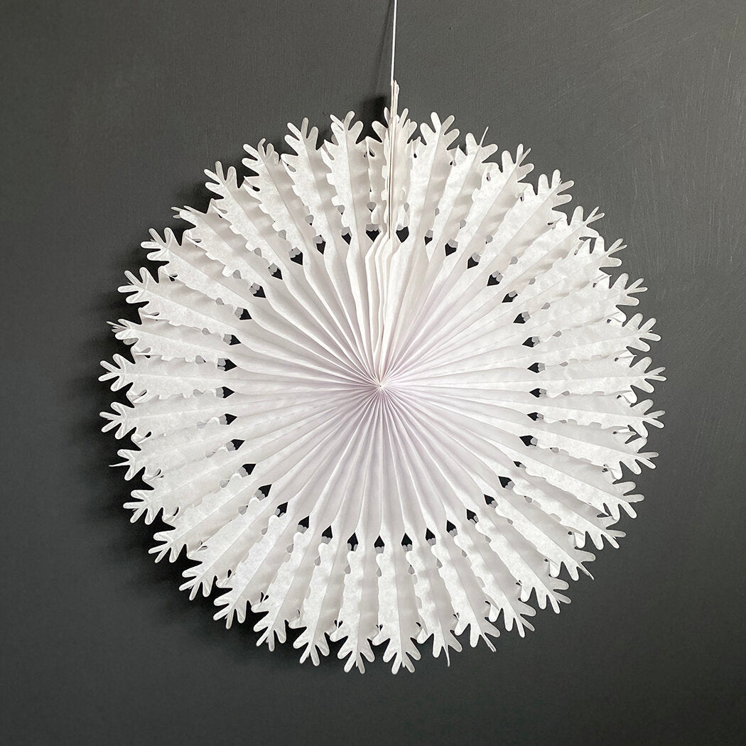 Large white paper snowflake decoration; pleated, circular design with scalloped edges.