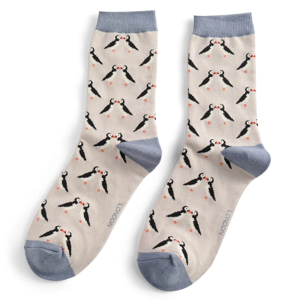 Pair of beige socks with a repeating pattern of kissing puffins.  The socks have a light blue cuff.