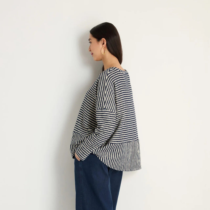 women wearing a striped navy and cream top.