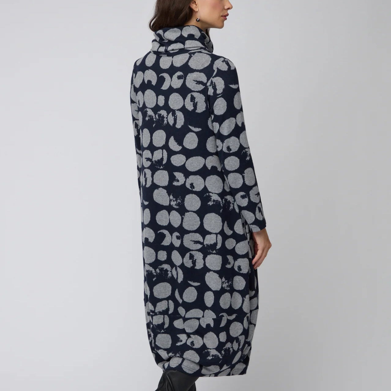 Long patterned coat worn by a person on a plain background