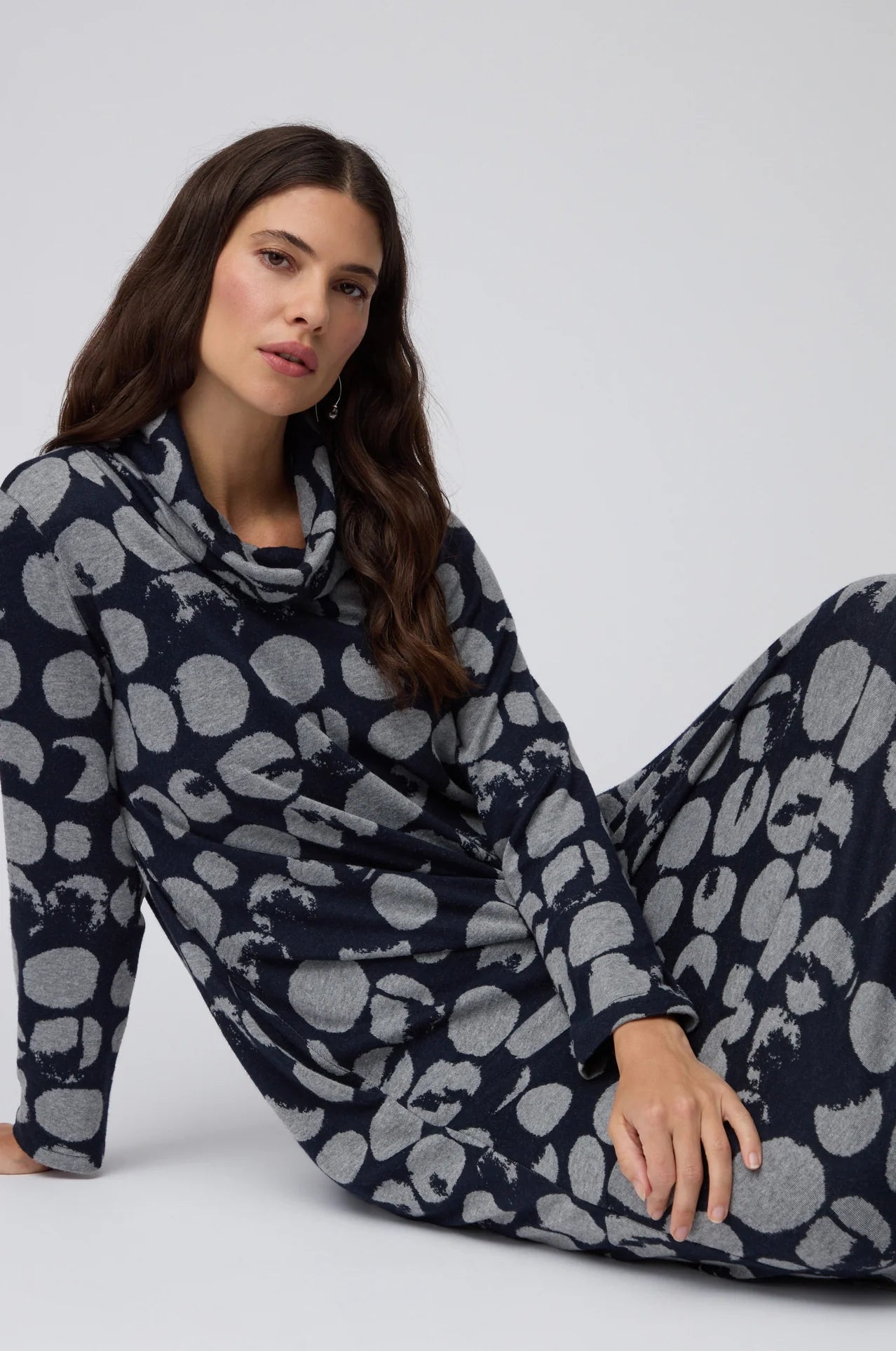 Woman wearing a navy blue and gray patterned loungewear set on a white background