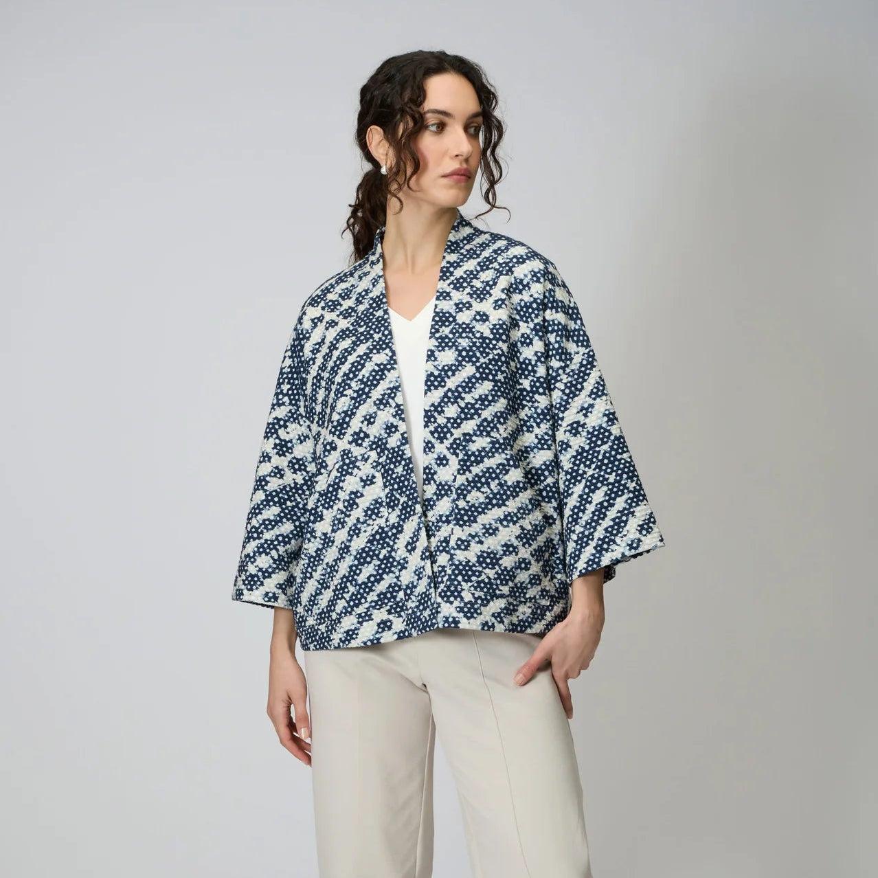 Women wearing a navy and white diamond shaped tie dye jersey open front jacket. 