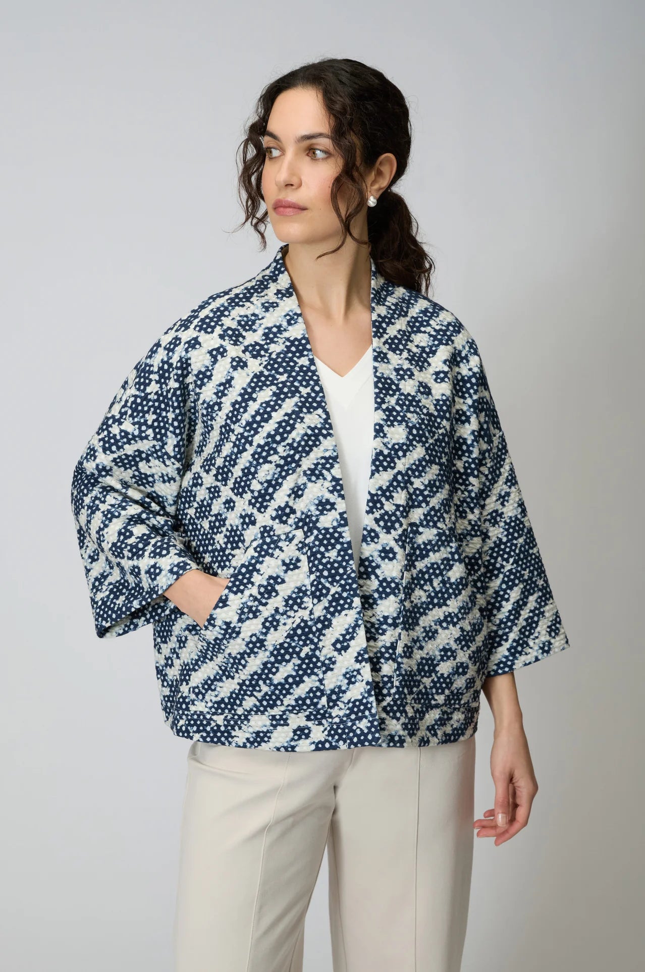Women wearing a navy and white diamond shaped tie dye jersey open front jacket. 