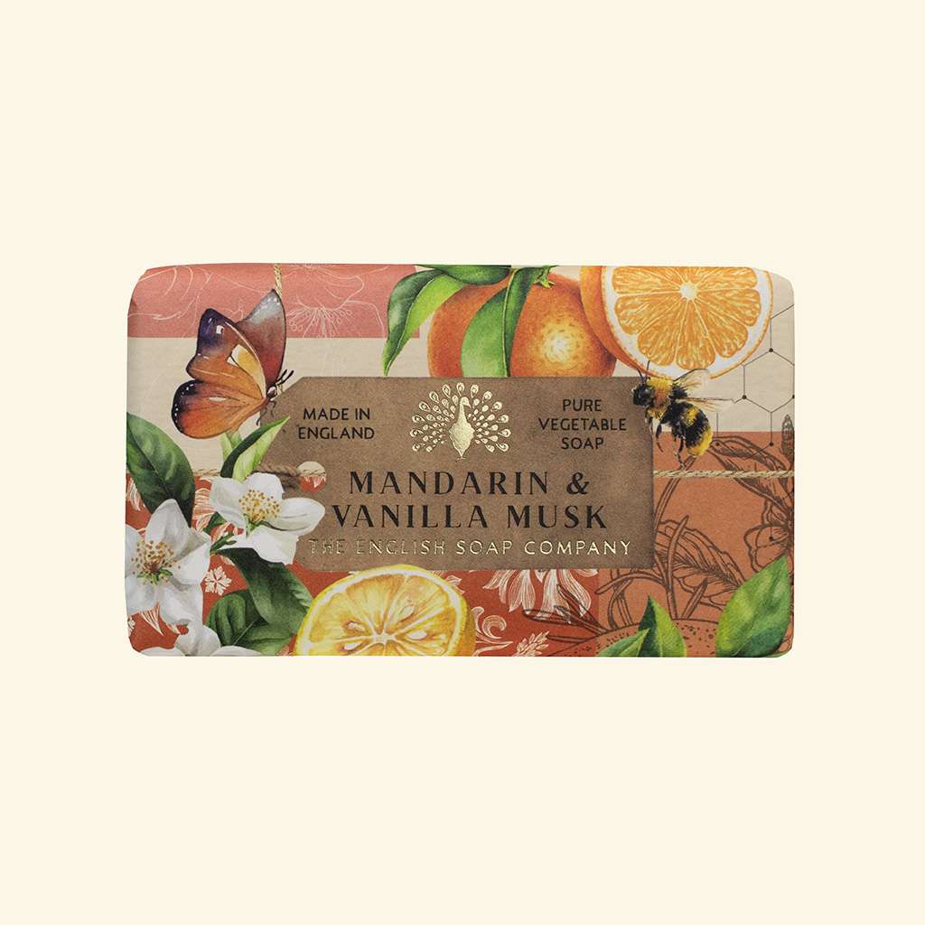 A rectangular bar of soap wrapped in decorative paper packaging featuring citrus slices, flowers, a butterfly, and a bee, with a central label reading 'MANDARIN & VANILLA MUSK' and 'The English Soap Company'.