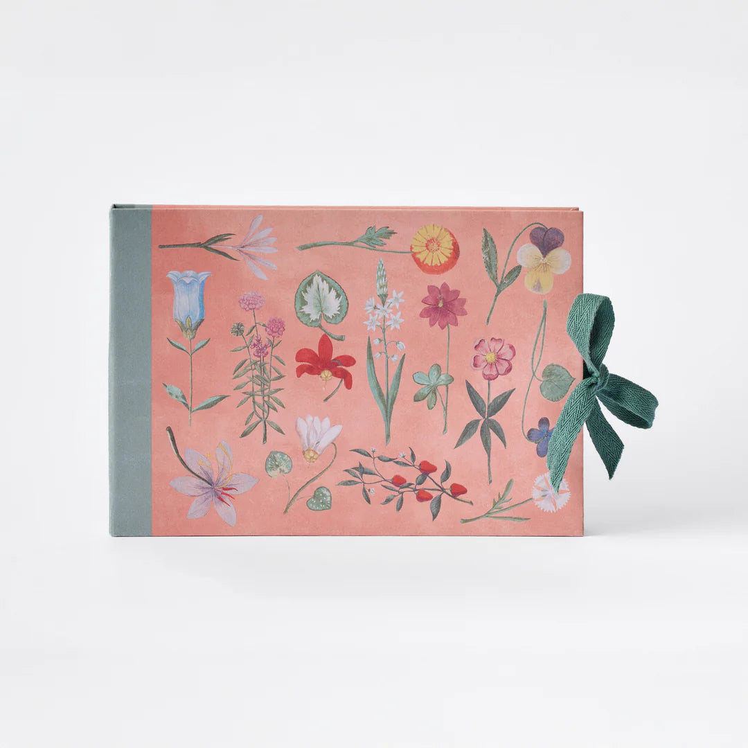 Floral notebook with a green ribbon on a white background