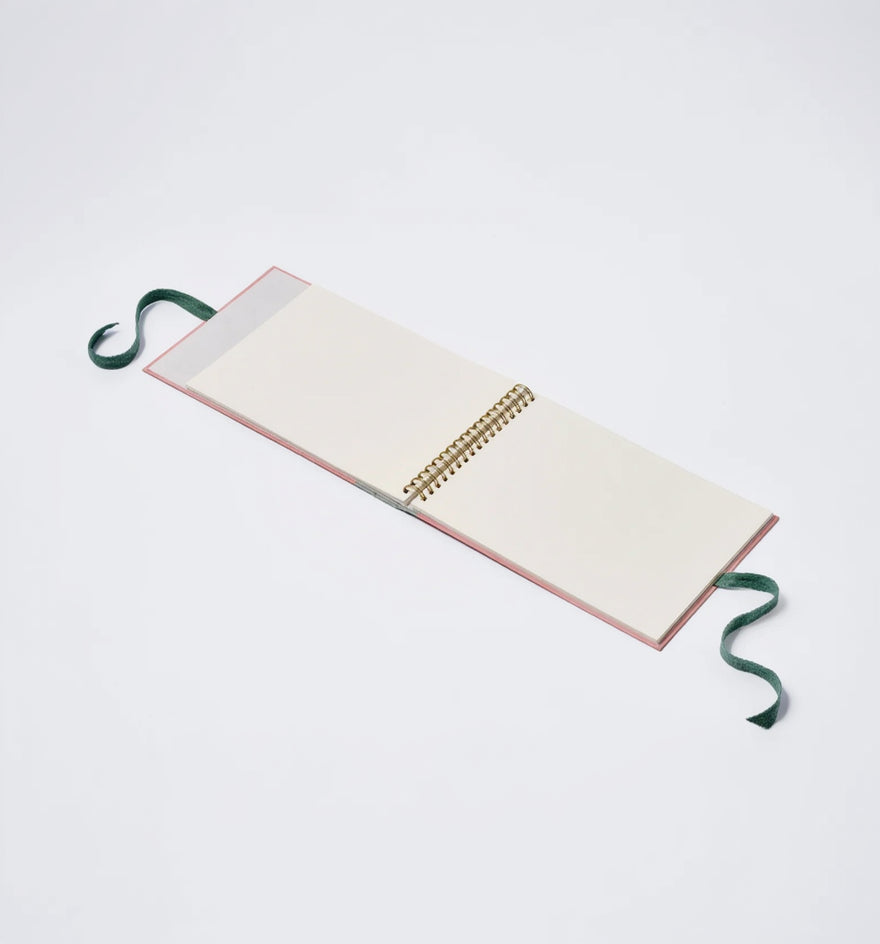 Open notebook with a green ribbon on a white background