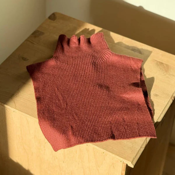 Red knitted fingerless glove on a cardboard box