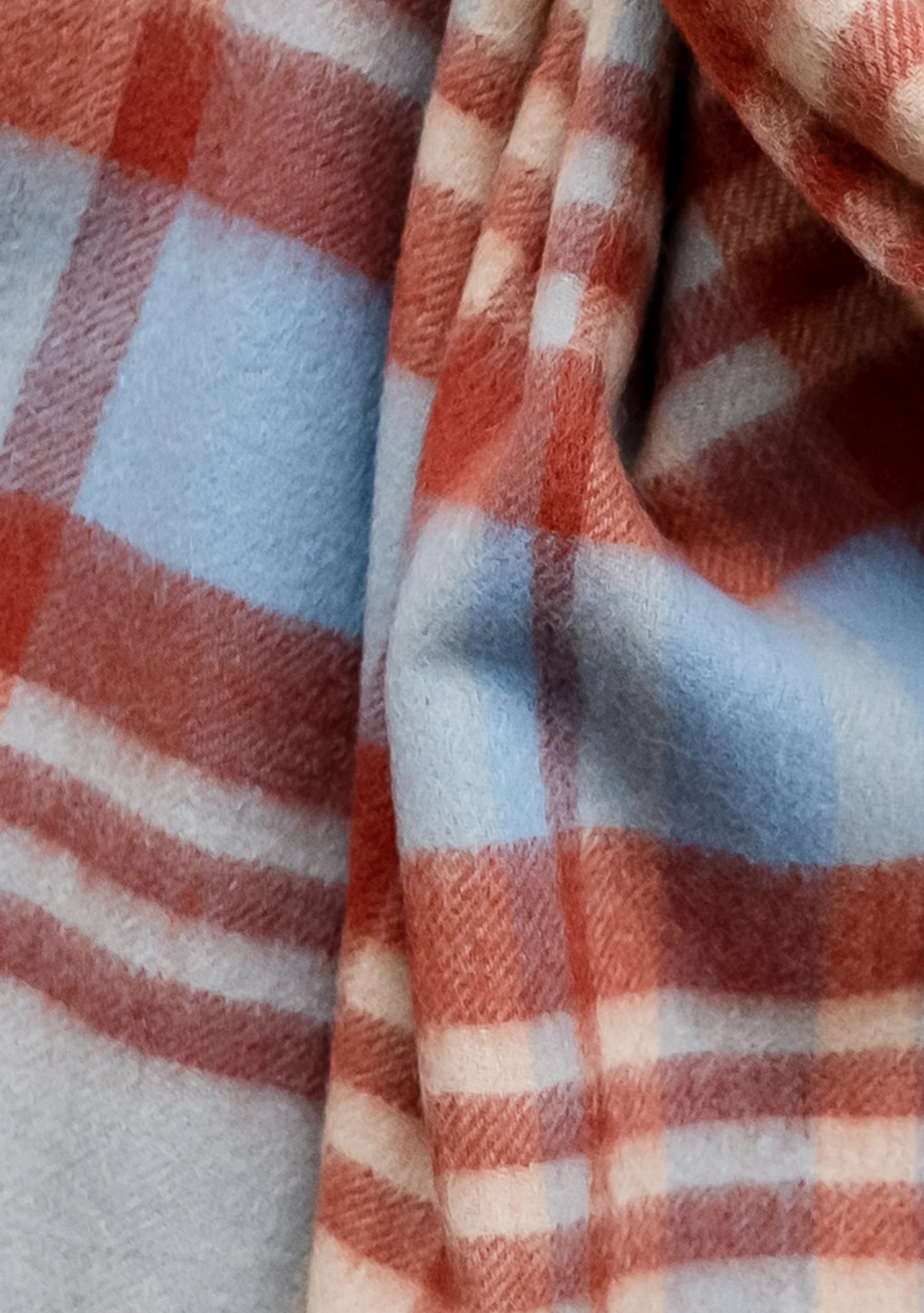 Soft, textured plaid fabric in dusty rose, light blue, and off-white.
