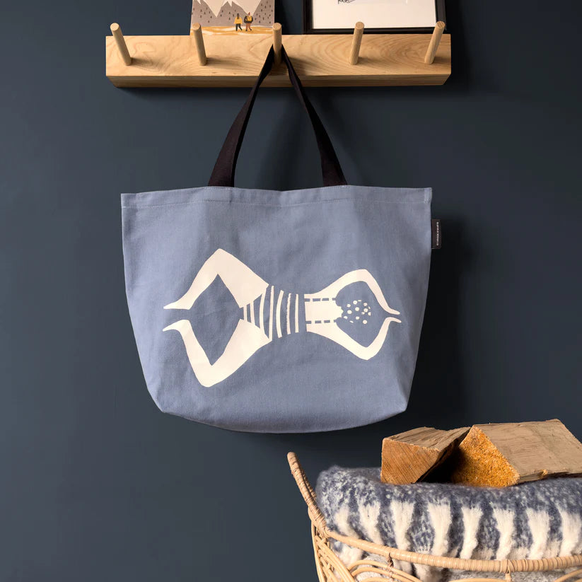 Blue canvas tote bag featuring a white stylized illustration of a woman in a swimsuit.