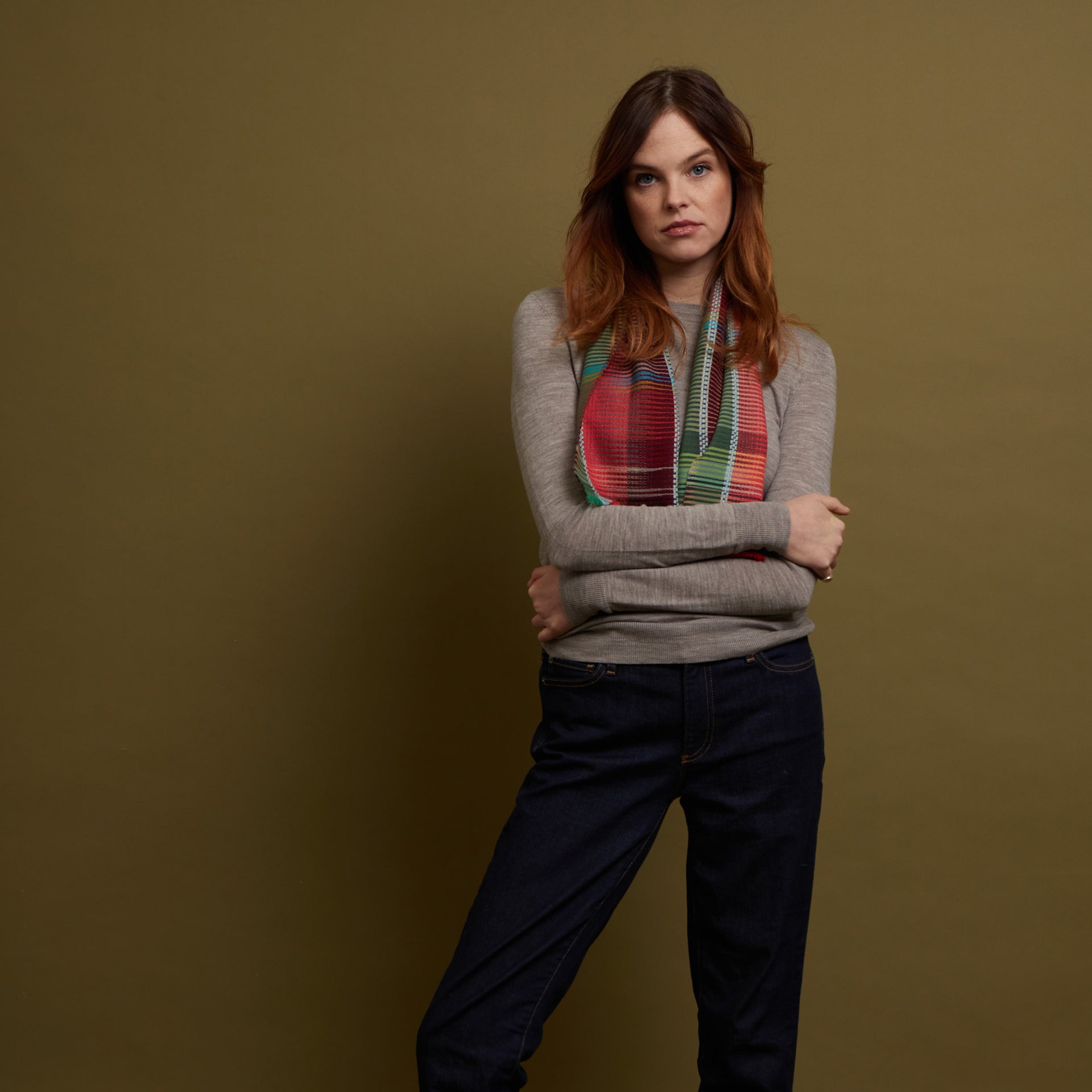 Multicolored woven scarf with red, green, and teal stripes.