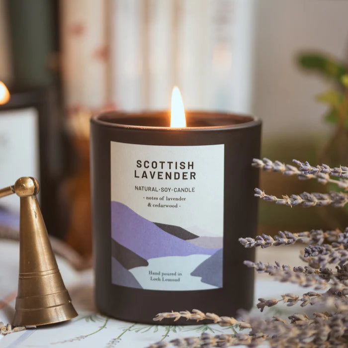 Lit Scottish Lavender natural soy candle in a dark jar with a minimalist label.