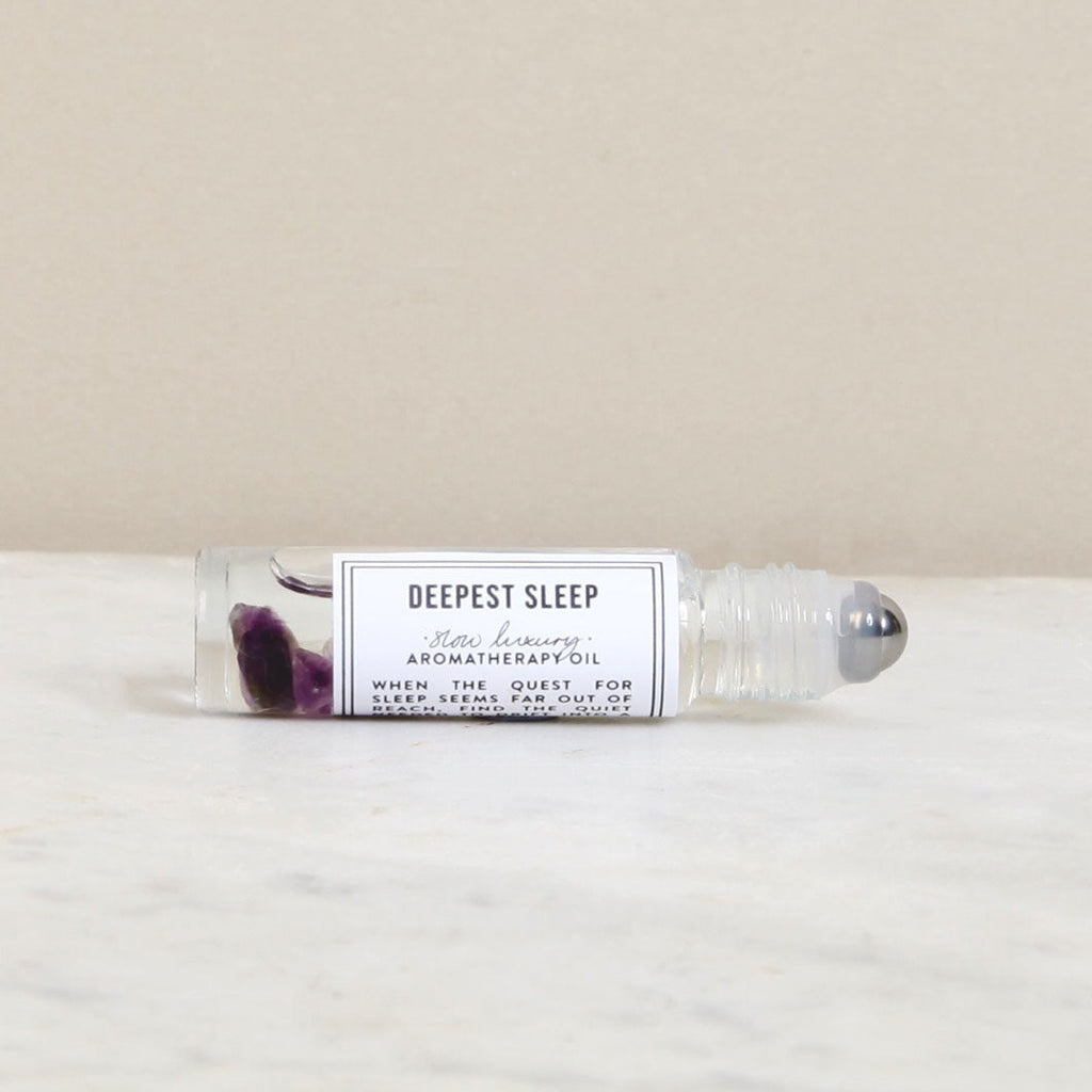 Norfolk Natural Living, 'Deepest Sleep' Pulse Point Oil in a clear roller applicator bottle positioned on its side with black and white label affixed