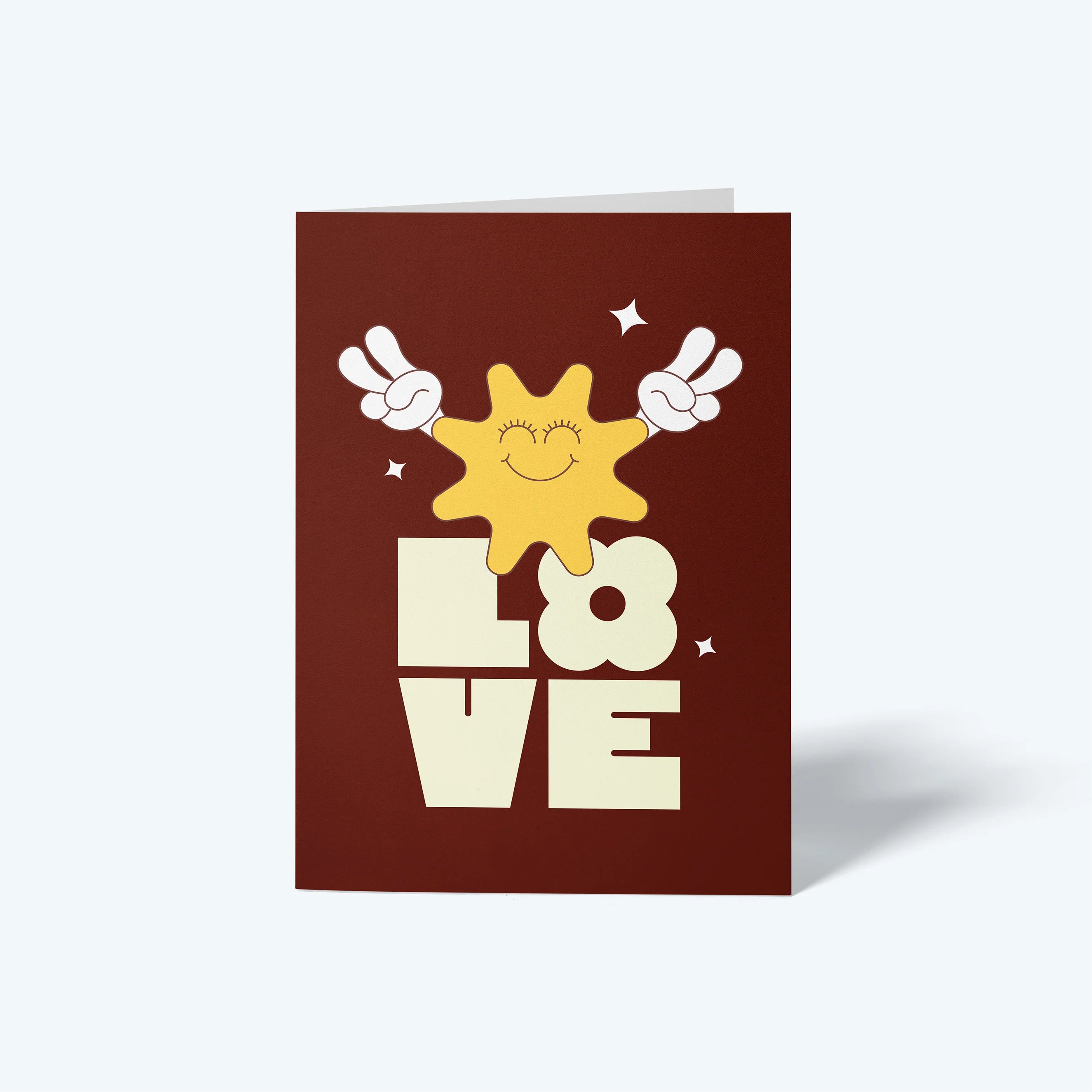 Greeting card with a sun and 'LOVE' text on a brown background