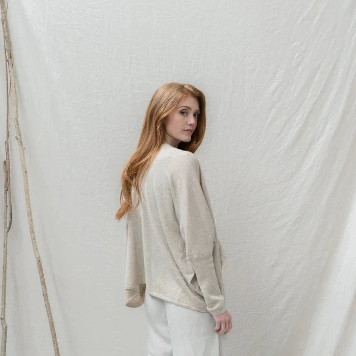 Beige linen blend cardigan with a relaxed, asymmetrical hem and long sleeves.
