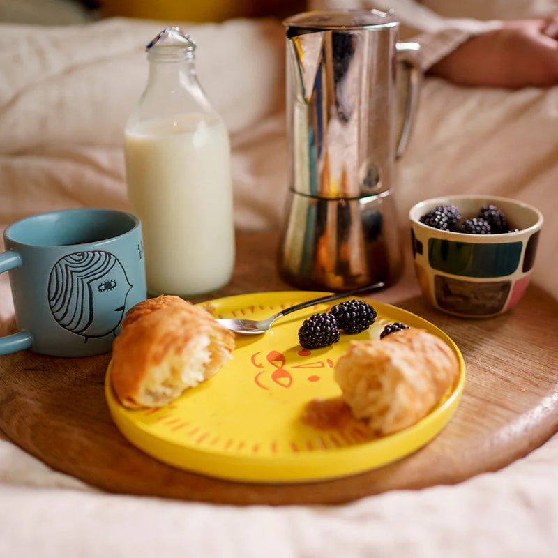Breakfast tray with coffee, milk, and pastries on a bed