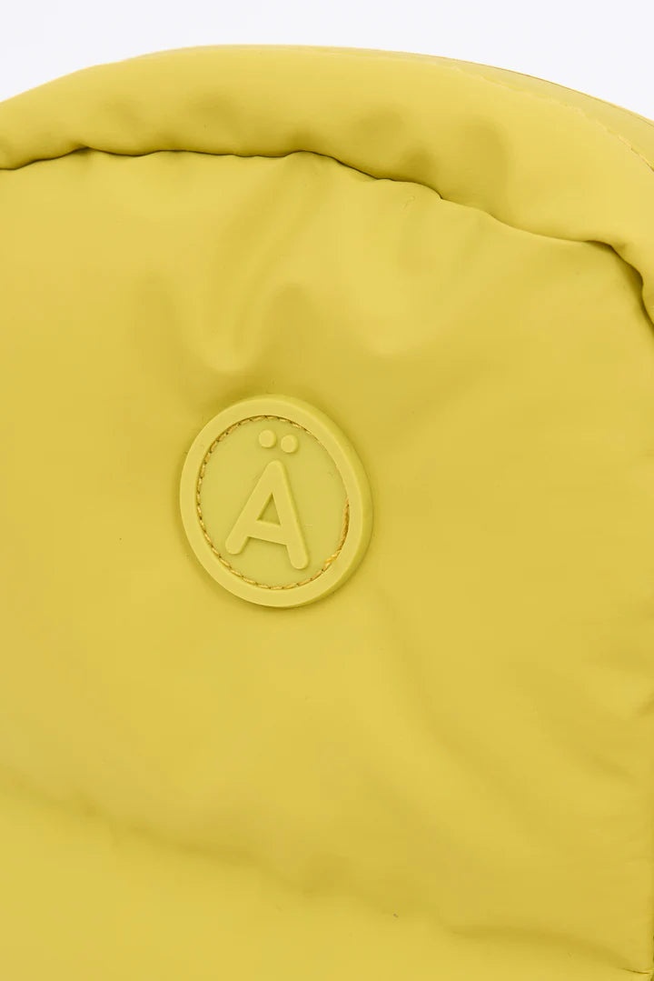 Close-up of a yellow bag with a brand logo on a white background