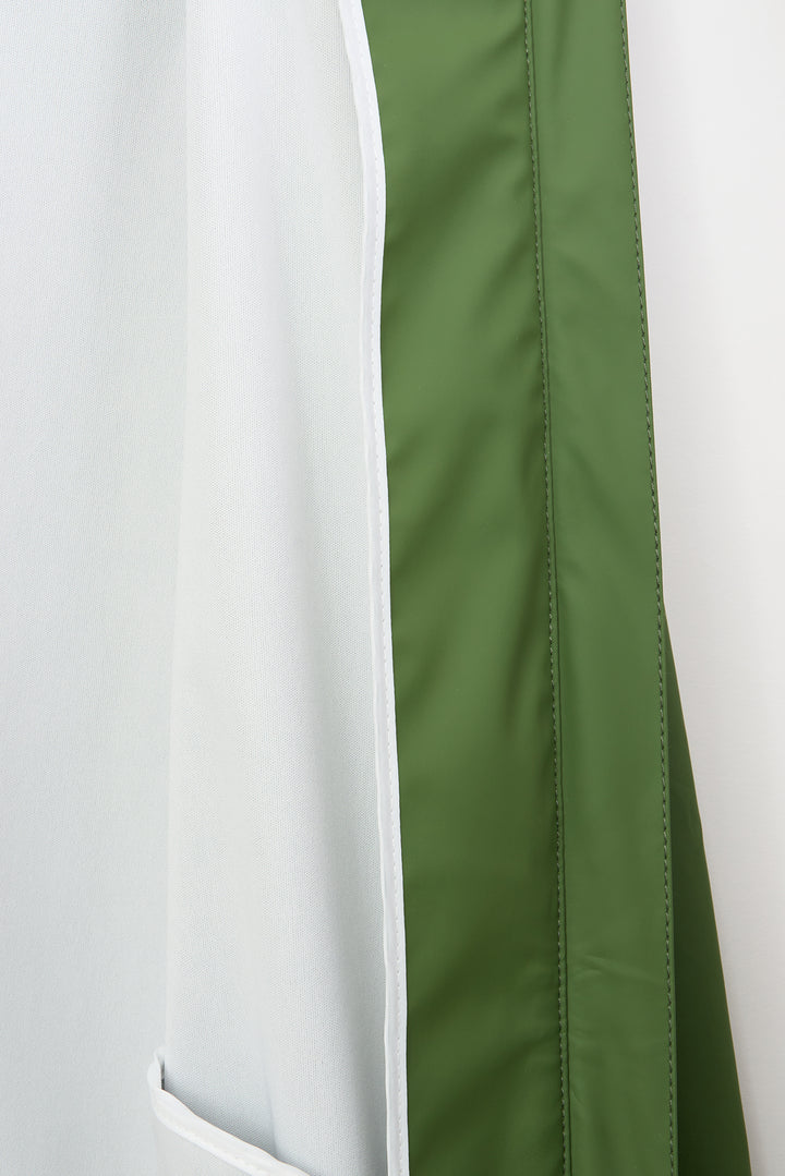 Close-up of a white and olive green garment, showing a vertical green stripe running down the side with a white border.