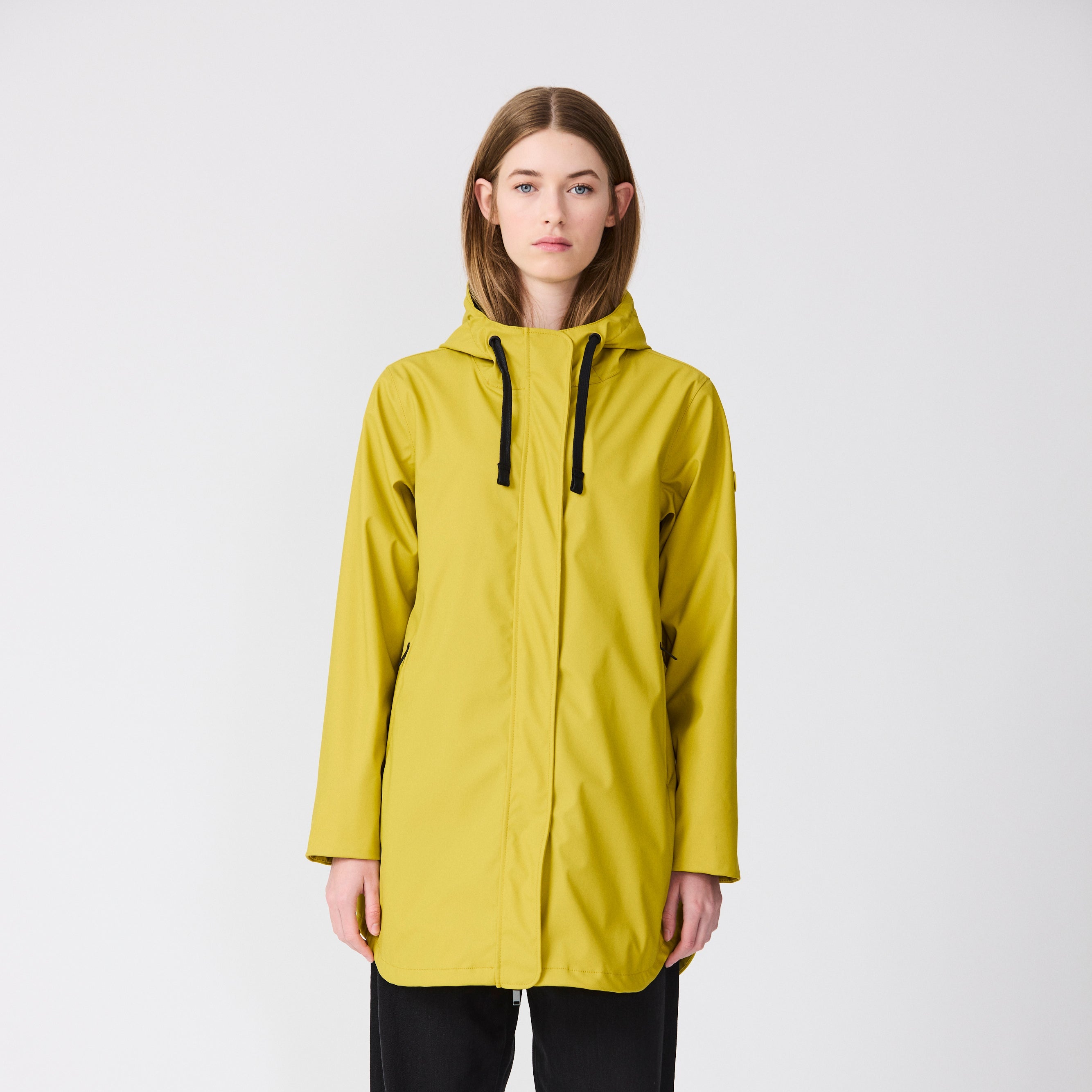 Person wearing a yellow raincoat on a white background